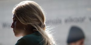 Μια ξανθιά γυναίκα με κρίκους και πράσινη μπλούζα