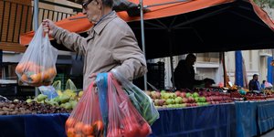Ηλικιωμένος με σακούλες με τρόφιμα στην λαϊκή αγορά