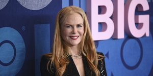 H Nικόλ Κίντμαν με μαύρο σακάκι με παγιέτες χαμογελάει στον φακό 