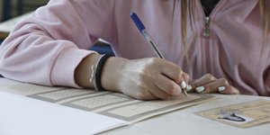Μια υποψήφια συμπληρώνει τα στοιχεία της στο γραπτό των πανελληνίων εξετάσεων