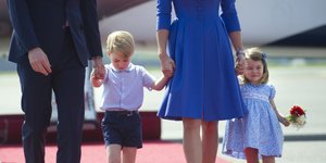 Η πριγκίπισσα Σάρλοτ και ο πρίγκιπας Τζορτζ περπατούν και τους κρατούν οι γονείς τους