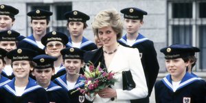 Η πριγκίπισσα Νταϊάνα κρατά λουλούδια και χαμογελάει