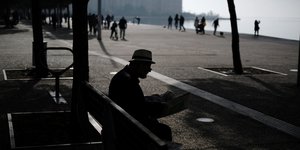 Ηλικιωμένος διαβάζει εφημερίδα στην παραλία της Θεσσαλονίκης