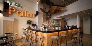 Στο εσωτερικό του Under the Palm, με καρέκλες, μπάρα, ποτά