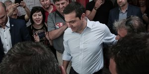 Αλέξης Τσίπρας με άσπρο πουκάμισο κοιτάει κάτω