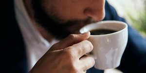 Αντρας με μούσι πίνει καφέ