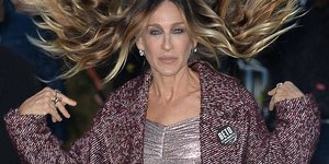 Η Σάρα Τζέσικα Πάρκερ με μοβ παλτό και φόρεμα