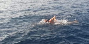 Αντρας κολυμπά στη θάλασσα