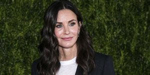 Η Κόρτνεϊ Κοξ με μπλε σακάκι και λευκό τοπ