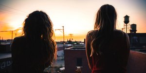 Δύο γυναίκες με μακριά ατενίζουν το ηλιοβασίλεμα