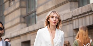 Γυναίκα με λευκό κοστούμι και αθλητικά