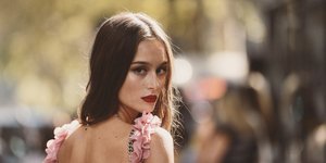 Γυναίκα με ροζ φόρεμα κοιτάει προς τα πίσω