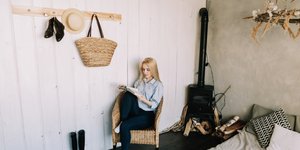 Ξανθιά γυναίκα σε κρεβατοκάμαρα διαβάζει βιβλίο 