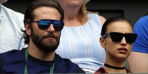 Ο Μπράντλεϊ Κούπερ και η Ιρίνα Σάικ φορούν γυαλιά ηλίου και παρακολουθούν αγώνα