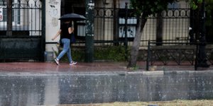 Γυναίκα με ομπρέλα σε δρόμο