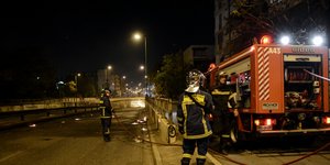 Πυροσβέστες με μάνικες δίπλα από πυροσβεστικό όχημα