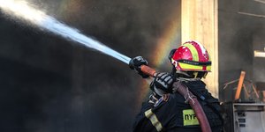 Πυροσβέστης ρίχνει νερό με την μάνικα