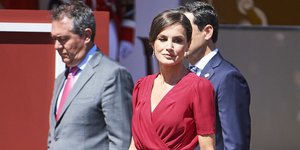 Η Λετίθια με κόκκινο φόρεμα περπατά και χαμογελά