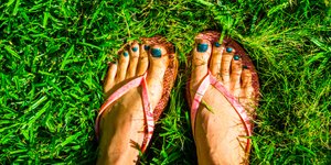 Γυναίκα με σαγιονάρες στο γρασίδι