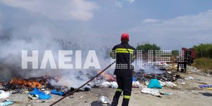 Πυροσβέστης σβήνει φωτιά σε χωματερή