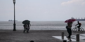 Κόσμος κρατάει ομπρέλες λόγω βροχής στη Θεσσαλονίκη