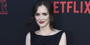 Η Γουαϊνόνα Ράιντερ με μαύρο φόρεμα και κόκκινο κραγιόν