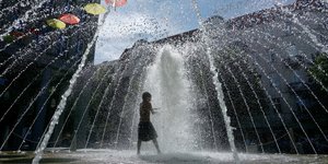 Αγόρι βρίσκει δροσιά σε συντριβάνι σε πλατεία το Βερολίνου