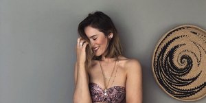 Η Ανίτα Μπραντ με ροζ μπικίνι και γκρι τοίχος από πίσω 