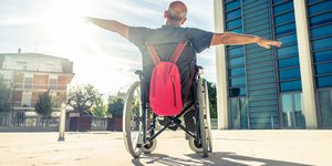 Αντρας σε αμαξίδιο με ανοιχτά χέρια