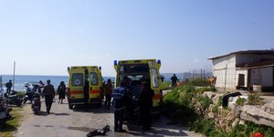 Ασθενοφόρα σε παραλία με γιατρούς και κόσμο
