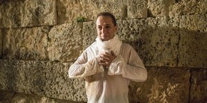 Ο Δημήτρης Λιγνάδης με λευκό πουκάμισο ποζάρει χαμογελώντας