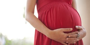 έγκυος γυναίκα με κόκκινο φόρεμα