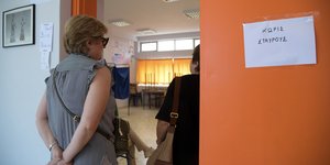 Μια γυναίκα περιμένει να ψηφίσει