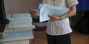 Μέλος της εφορευτικής επιτροπής κρατά στα χέρια του ψηφοδέλτια