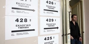 Ενας ψηφοφόρος στέκει δίπλα στην είσοδο εκλογικού τμήματος