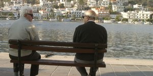 Δύο ηλικιωμένοι συζητούν σε παγκάκι