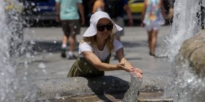 Γυναίκα δροσίζεται σε συντριβάνι