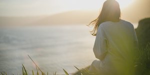 Γυναίκα με γυρισμένη πλάτη μπροστά στη θάλασσα