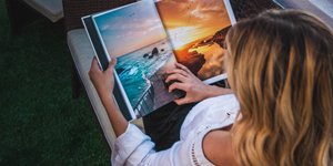 Μια γυναίκα ξαπλωμένη καθισμένη στον καναπέ διαβάζει περιοδικό