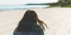 Μια γυναίκα με καστανά μακριά μαλλιά στην παραλία