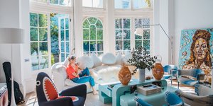 Μια γυναίκα πίνει καφέ στο σαλόνι του σπιτιού της 