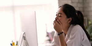 Γυναίκα χασμουριέται μπροστά από τον υπολογιστή