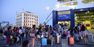 Επιβάτες επιβιβάζονται στο πλοίο της γραμμής στο λιμάνι του Πειραιά