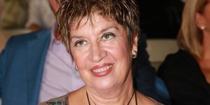 Η Λίτσα Διαμάντη χαμογελάει φορώντας μία σιθρού μπλούζα