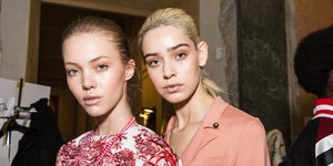 Δύο μοντέλα ποζάρουν στον φακό σε παρασκήνια επίδειξης μόδας