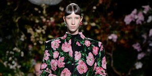 Γυναίκα φοράει φλοράλ πανωφόρι με μαύρο παντελόνι 