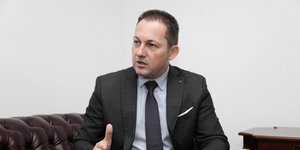 Ο Στέλιος Πέτσας κάθεται σε καναπέ