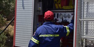 Πυροσβέστης μπροστά σε πυροσβεστικό όχημα