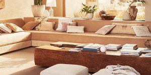 Ενα σαλόνι διαμερίσματος με καναπέ, μεγάλο τραπέζι και καθίσματα