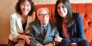 Τρεις άνθρωποι σε πορτοκαλί καναπέ